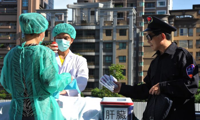 I praticanti del Falun Gong mettono in scena la sottrazione di organi a scopo di lucro nel corso di una manifestazione tenuta a Taipei nell'isola di Taiwan, il 20 luglio 2014.(Mandy Cheng/AFP/Getty Images)