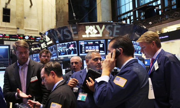 I trader della Borsa di New York Stock dopo la sospensione di quasi quattro ore, l'8 luglio 2015. Un membro di spicco di Anonymous sostiene che dietro l'interruzione si nasconde il regime cinese. (Spencer Platt/Getty Images) 