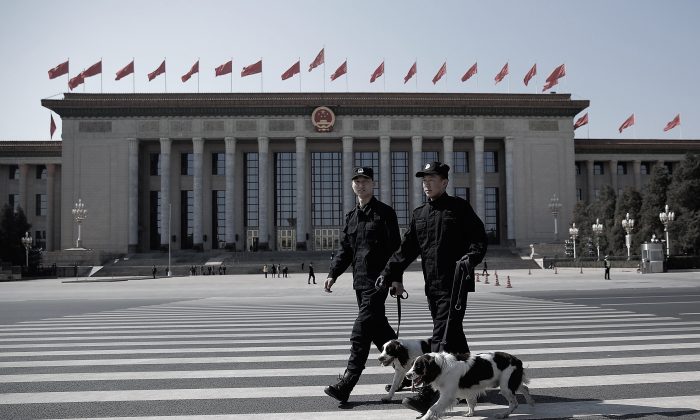 Due poliziotti con i cani poliziotto davanti alla Grande Sala del Popolo, prima della cerimonia di chiusura della Conferenza consultiva politica del popolo cinese, il 13 marzo 2015 a Pechino. (Lintao Zhang/Getty Images) 