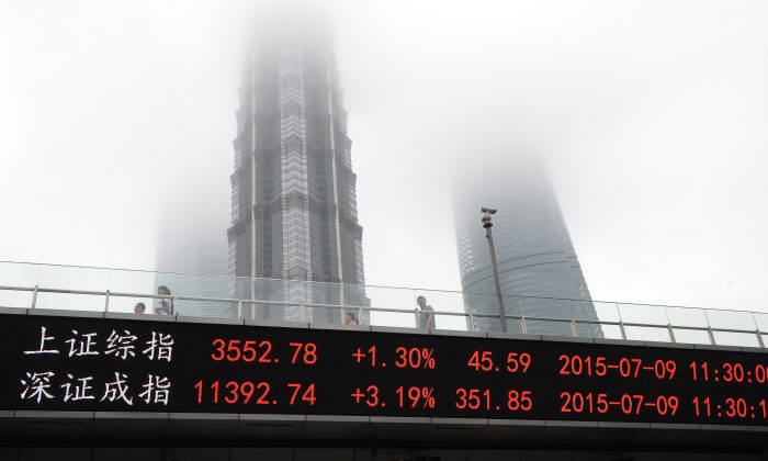 Uno schermo mostra l'indice di Shanghai e lo Shenzhen Component Index sul lato di un cavalcavia a Shanghai, il 9 luglio 2015. (STR/AFP/Getty Images) 