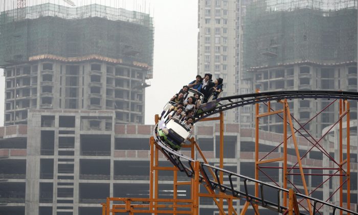 Le persone sulle montagne russe a Chongqing, il 27 settembre 2006. Nonostante le forti iniziezioni di liquidità e altre misure del regime cinese, il mercato finanziario cinese sta continunando le sue altalene. (Cina Foto/Getty Images) 