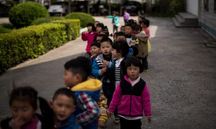 Bambini nel cortile della scuola professionale secondaria di Rudong, nella provincia di Jiangsu, il 17 aprile 2015 (JOHANNES EISELE / AFP / Getty Images) 