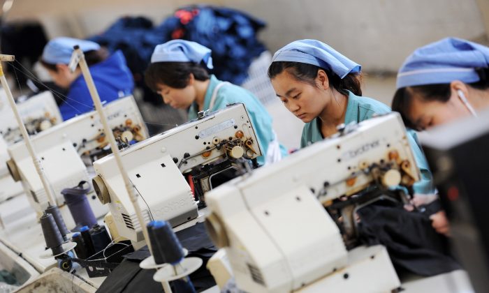 Operaie in una fabbrica d'abbigliamento nella provincia cinese dell'Anhui, nel 2014. Ultimamente per la Cina sta diventando sempre più importante mantenere la manodopera. (STR/AFP/Getty Images)