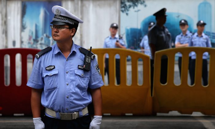 Poliziotto cinese di fronte al Tribunale Intermedio del Popolo a Jinan, Cina, il 25 agosto 2013. (Feng Li/Getty Images) 