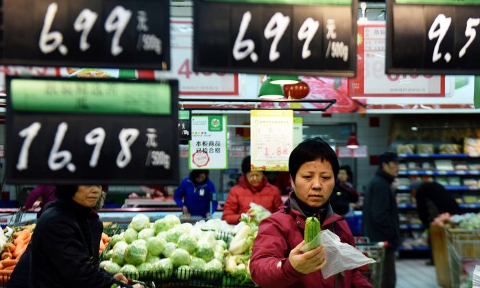 Una cliente seleziona le verdure in un supermercato di Hangzhou, nella provincia  di Zhejiang, Cina, il 10 marzo 2016. (STR / AFP / Getty Images)