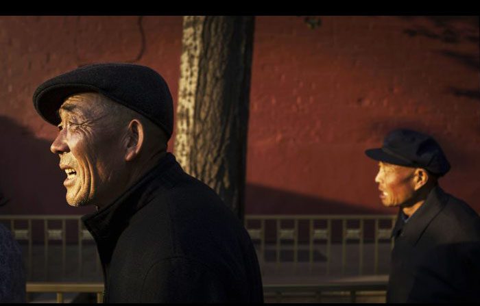 I pensionati cinesi camminano per strada a Pechino il 16 ottobre 2014. (Kevin Frayer / Getty Images)