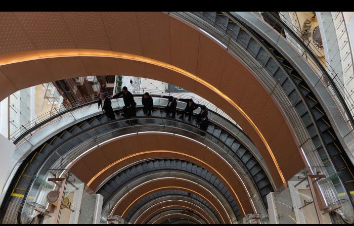 I clienti sull'ascensore a spirale in un centro commerciale appena inaugurato a Shanghai il 17 marzo 2015. Gli investimenti esteri della Cina sembrano rallentare. (STR / AFP / Getty Images)