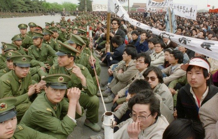 Alcuni centinaia dei 200mila manifestanti studenteschi della democrazia si sono riuniti in Piazza Tiananmen seduti faccia a faccia con i poliziotti al di fuori della Grande Sala del Popolo, 22 aprile 1989. (Catherine Henriette / AFP / Getty Images)