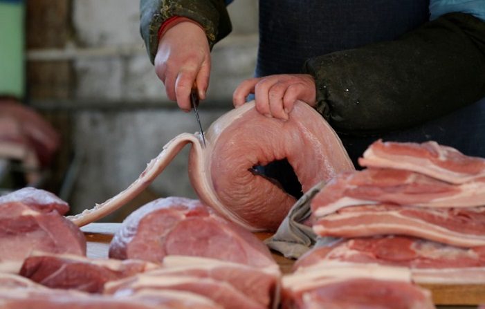 Un macellaio taglia un pezzo di maiale in un mercato a Pechino, Cina, 25 marzo 2016 (Reuters / Jason Lee / File Photo).