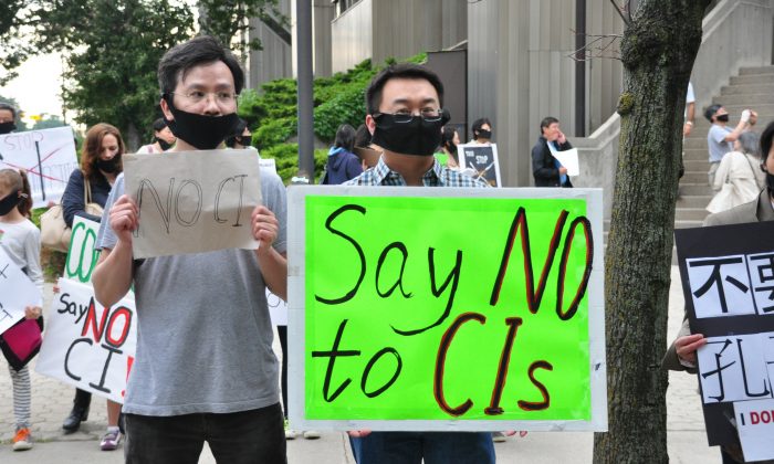 Manifestanti a Toronto l'11 gennaio 2014, chiedono al consiglio scolastico della città canadese di non implementare i programmi dell'Istituto Confucio nelle scuole. (Allen Zhou/Epoch Times)