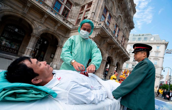 Praticanti del Falun Gong rappresantano il prelievo forzato di organi operato dal regime cinese, in occasione di una manifestazione di protesta a Vienna, Austria, il 1° ottobre 2018. (Joe Klamar/AFP tramite Getty Images)