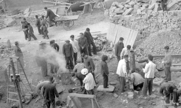 I dipendenti dello Shin Chiao Hotel di Pechino costruiscono nel cortile dell'albergo (sullo sfondo) nell'ottobre 1958 un piccolo e rudimentale forno fusorio per la fusione dell'acciaio durante il periodo del "Grande Balzo in avanti". (JACQUET-FRANCILLON/AFP/Getty Images)