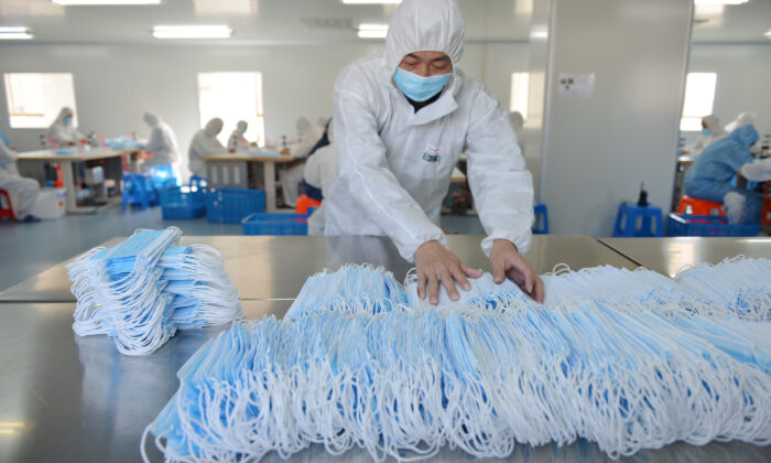 Un operaio di una fabbrica di Nanchino, a Jiangsu, sta smistando le mascherine, il 18 febbraio 2020. (STRAFP tramite Getty Images)