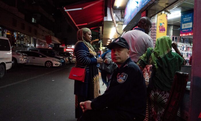 Un uomo della sicurezza all'ingresso del distretto «»Piccola Africa«» a Guangzhou, la capitale della provincia del Guangdong, Cina, il primo marzo 2018. (FRED DUFOURAFP tramite Getty Images)