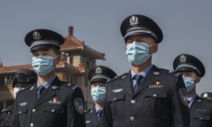 Agenti di polizia cinesi con maschere protettive alla stazione ferroviaria di Pechino il 4 aprile 2020. (Kevin Frayer / Getty Images)