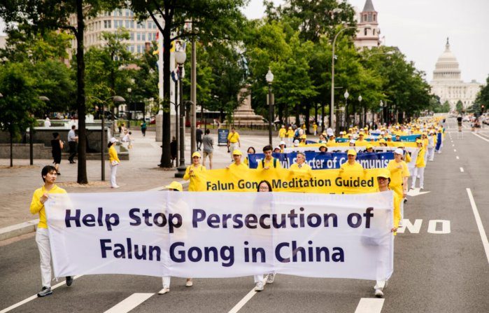 I praticanti locali del Falun Gong partecipano a una grande marcia per chiedere la fine della persecuzione della pratica spirituale in Cina, a Washington, il 20 giugno 2018. (Edward Dye / The Epoch Times)