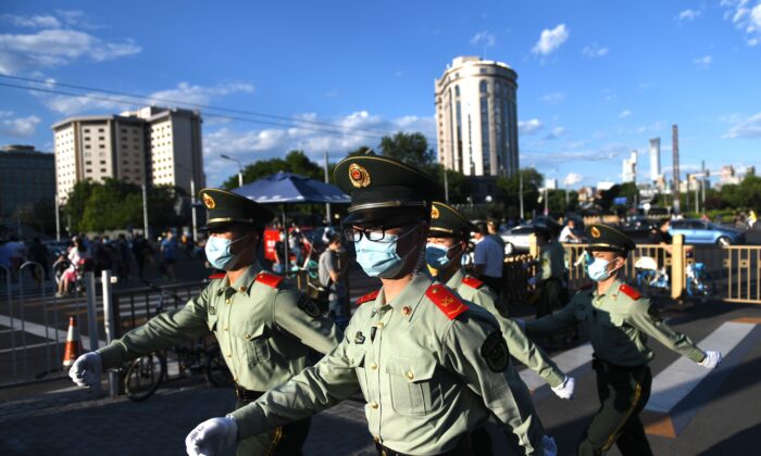 Gli agenti di polizia paramilitare pattugliano una strada dopo la sessione di chiusura della Conferenza consultiva politica del popolo cinese (Cppcc) a Pechino il 27 maggio 2020 (Greg Baker / AFP tramite Getty Images)