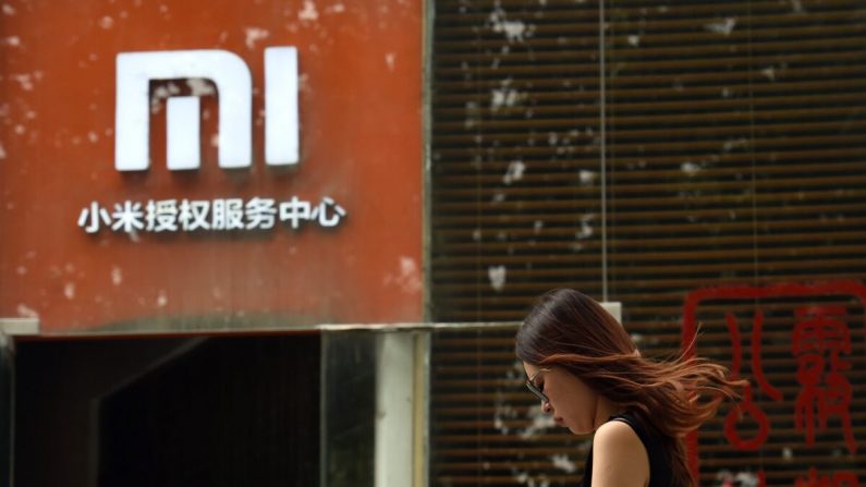 Una donna cammina davanti a un logo Xiaomi fuori da un centro di assistenza Xiaomi a Pechino, il 5 agosto 2015. (Greg Baker/AFP via Getty Images)