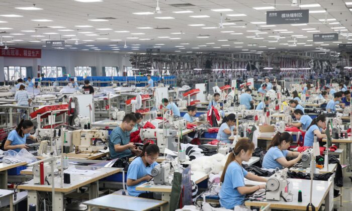 I dipendenti producono piumini in una fabbrica per l'azienda di abbigliamento cinese Bosideng a Nantong, nella provincia orientale di Jiangsu, il 24 settembre 2019. (Str/Afp via Getty Images)