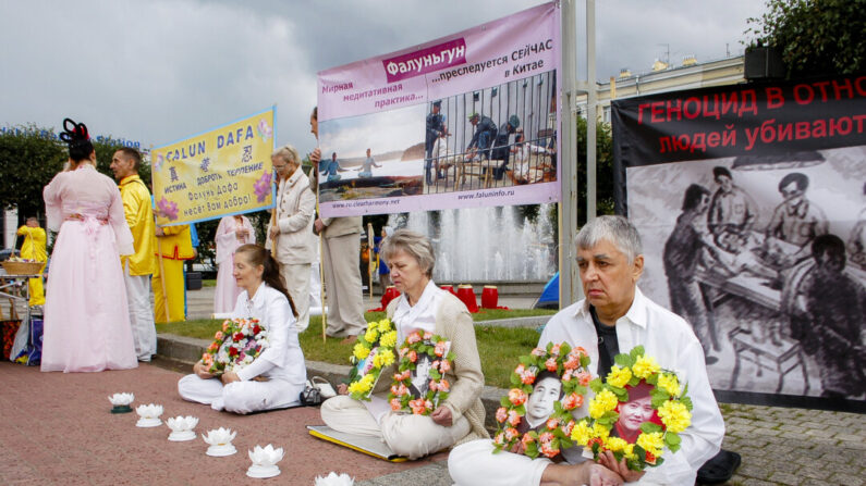 Praticanti del Falun Gong si riuniscono nella piazza davanti alla stazione Finlyandsky di San Pietroburgo, in Russia, il 20 luglio 2013, per commemorare i praticanti perseguitati a morte in Cina. (Irina Oshirova/Epoch Times)