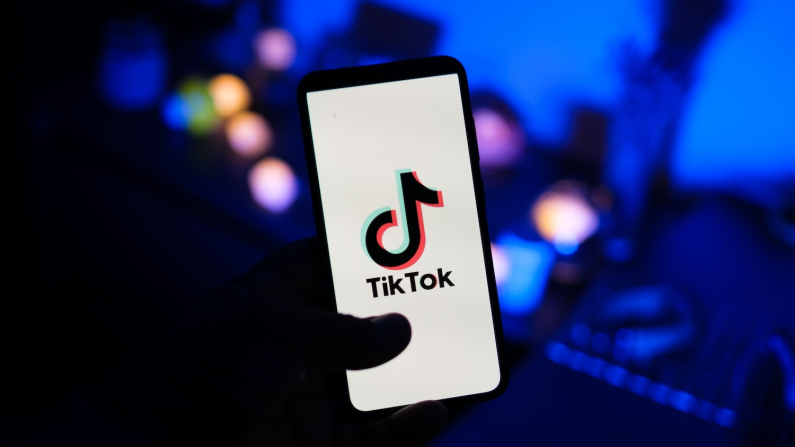 A man holds a phone displaying the TikTok app, in this file photo, on Aug. 11, 2024. (Oleksii Pydsosonnii/The Epoch Times)