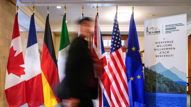 Un uomo passa davanti alle bandiere dei membri del G7 al Manoir Richelieu prima del vertice dei ministri degli Esteri del G7 a La Malbaie, Québec, Canada, 12 marzo 2025. REUTERS/Mathieu Belanger/Foto d'archivio.