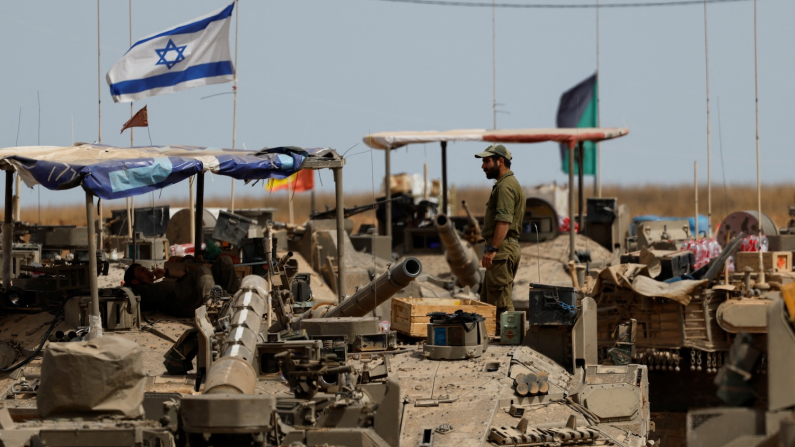 Soldato israeliano in piedi su un carro armato vicino al confine tra Israele e Gaza, 17 maggio 2025 (foto: REUTERS/Amir Cohen)