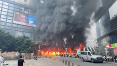 Fiamme e fumo nero per un incendio in un parcheggio cinese