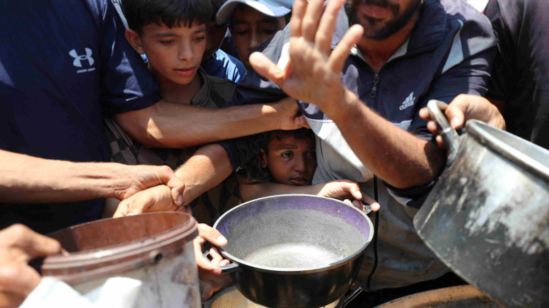 Palestinesi aspettano di ricevere cibo a Gaza City, 21 giugno 2025. REUTERS/Mahmoud Issa/Foto d'archivio