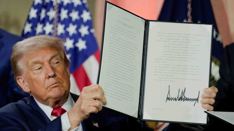 Il presidente degli Stati Uniti, Donald Trump, mostra un ordine esecutivo relativo all'intelligenza artificiale dopo averlo firmato durante il vertice "Winning the AI Race" a Washington DC, Stati Uniti, 23 luglio 2025. REUTERS/Kent Nishimura