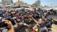 Palestinesi affollano una mensa di Gaza City