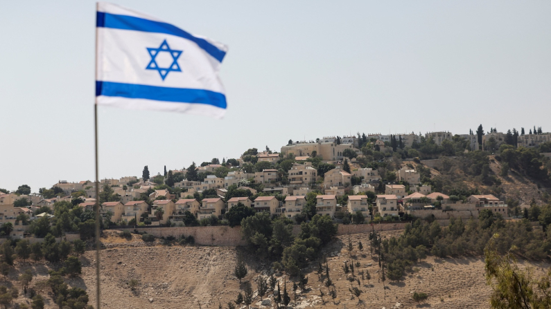 Bandiera israeliana, sullo sfondo è visibile una parte dell'insediamento israeliano di Maale Adumim, nella Cisgiordania (REUTERS/Ronen Zvulun).